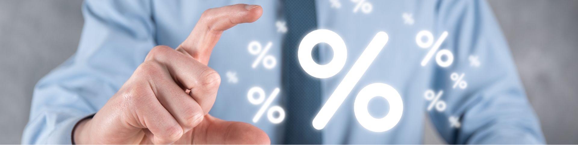Homme en costume tenant un symbole de pourcentage lumineux entre ses doigts, représentant un concept de taux ou de réduction.